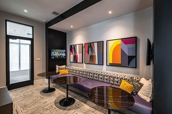 a living room with paintings on the wall and a purple couch at Altis Grand Kendall, Florida, 33186