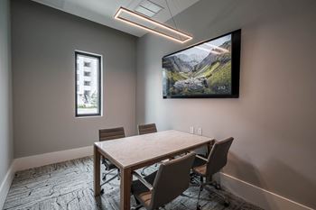 a conference room with a tv and a table with chairs at Altis Grand Kendall, Florida