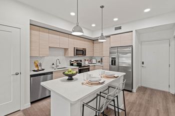 a kitchen with a large island and stainless steel appliances at Altis Grand Kendall, Miami, FL 33186