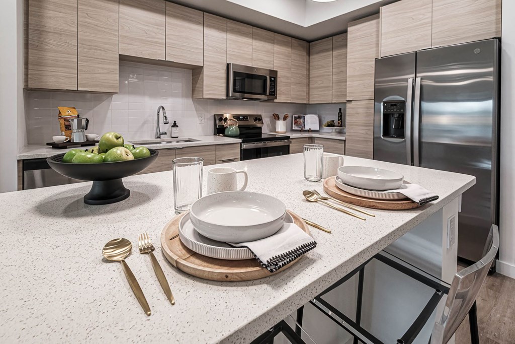 a kitchen with stainless steel appliances and white counter tops a kitchen with stainless steel appliances and white counter tops at Altis Grand Kendall, Miami, FL
