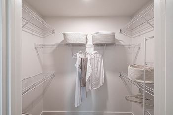 a walk in closet with wire shelves and clothes at Altis Grand Kendall, Florida