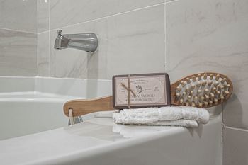 a white bathroom with a towel rack and a soap dispenser and a bath tub at Altis Grand Kendall, Florida