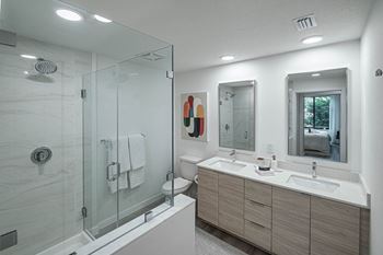a bathroom with a shower and a sink and a mirror at Altis Grand Kendall, Miami