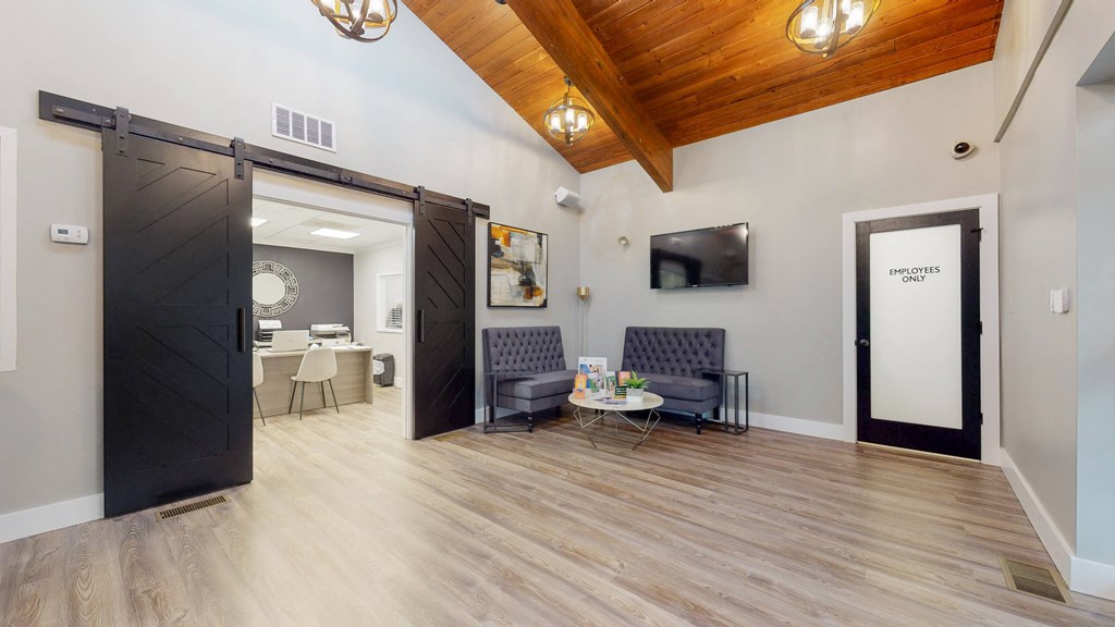 a living room with a wooden floor and a sliding barn door
