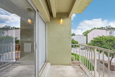 A balcony with a glass door leading to a patio.