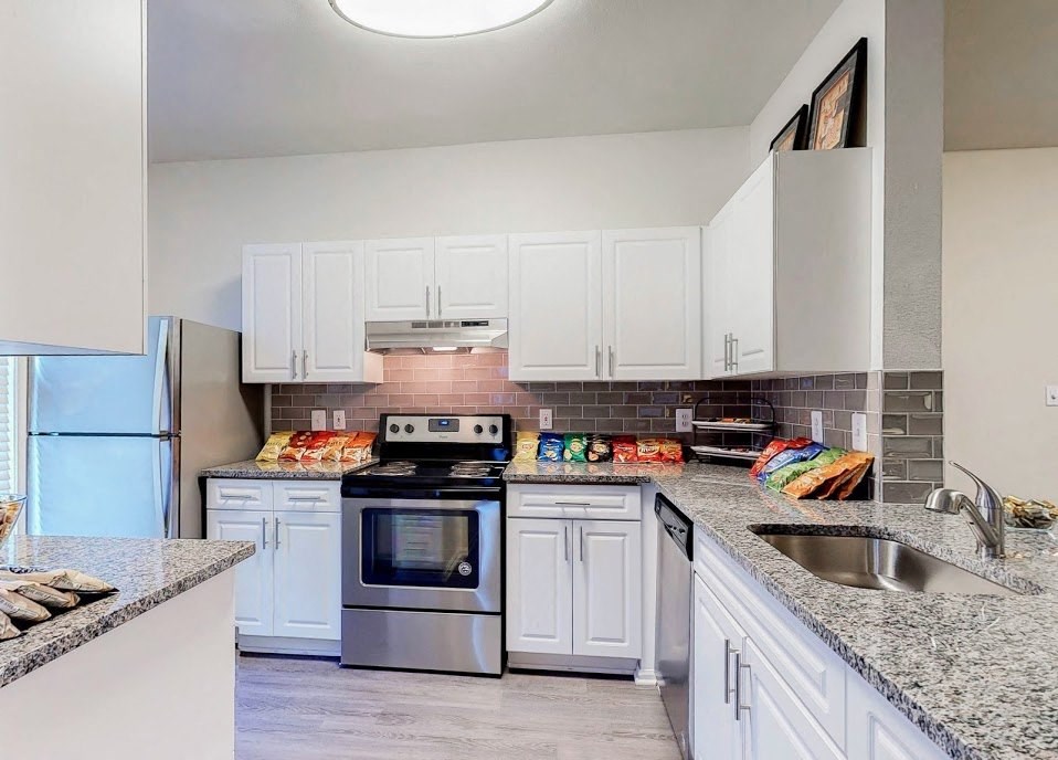 a kitchen with white cabinets and stainless steel appliances