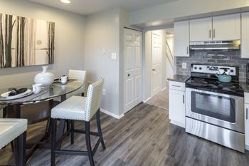 a kitchen with a stove and a table and chairs
