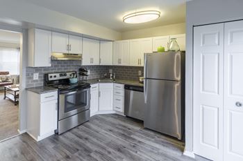 a kitchen with stainless steel appliances and white cabinets