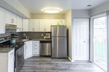 a kitchen with stainless steel appliances and white cabinets
