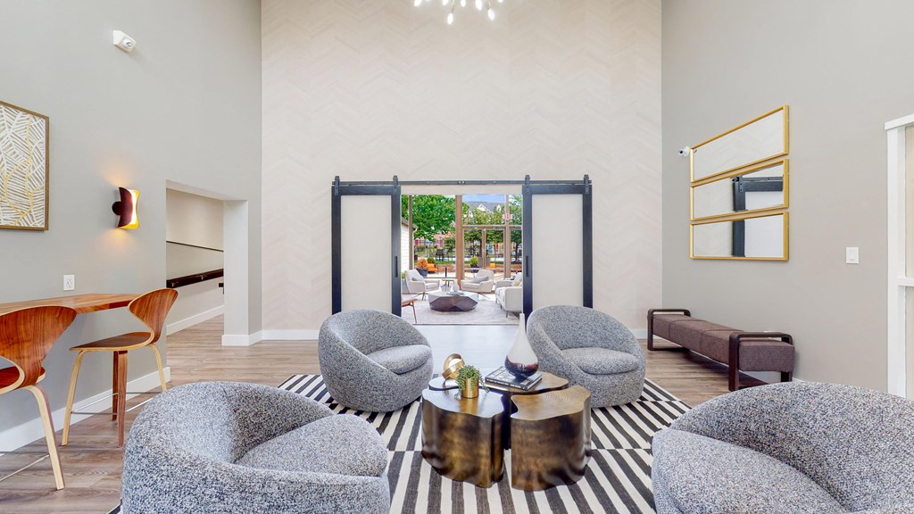 a living room with chairs and a table and a sliding glass door