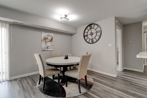 A dining room with a round table and chairs.