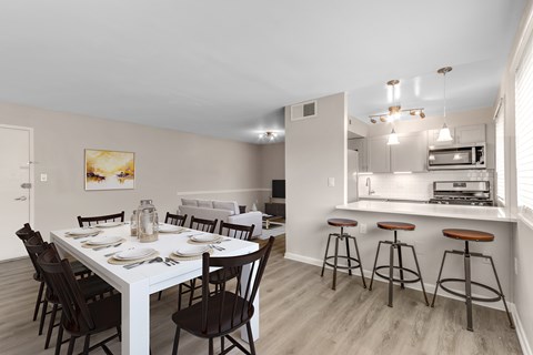 A dining room with a white table and chairs.
