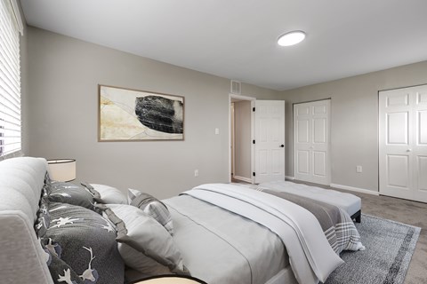 A bedroom with a large bed and a painting on the wall.