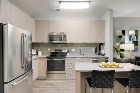 a modern kitchen with stainless steel appliances and a white counter top