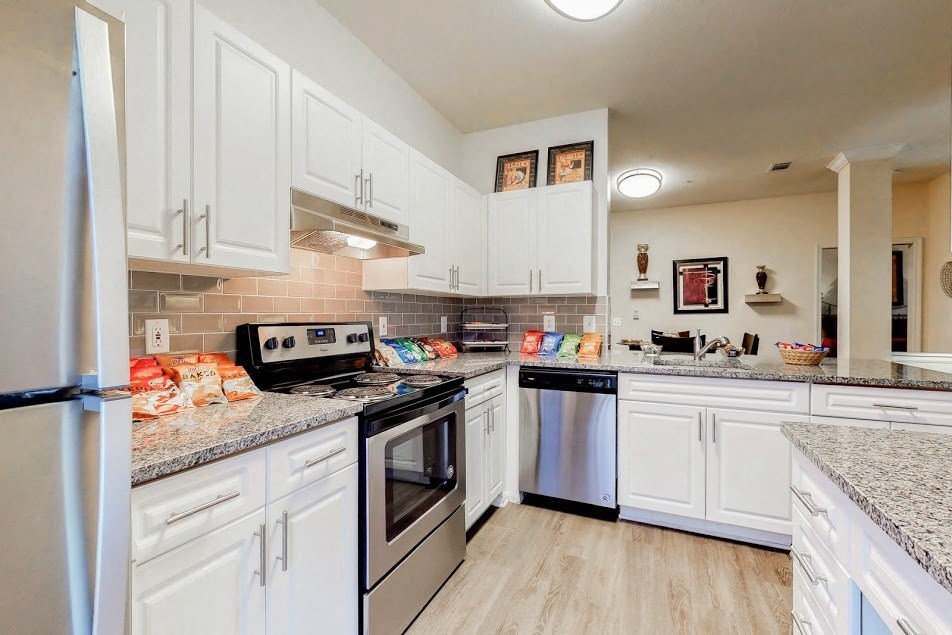 a kitchen with white cabinets and stainless steel appliances