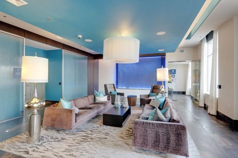 a living room with couches and chairs and a blue ceiling