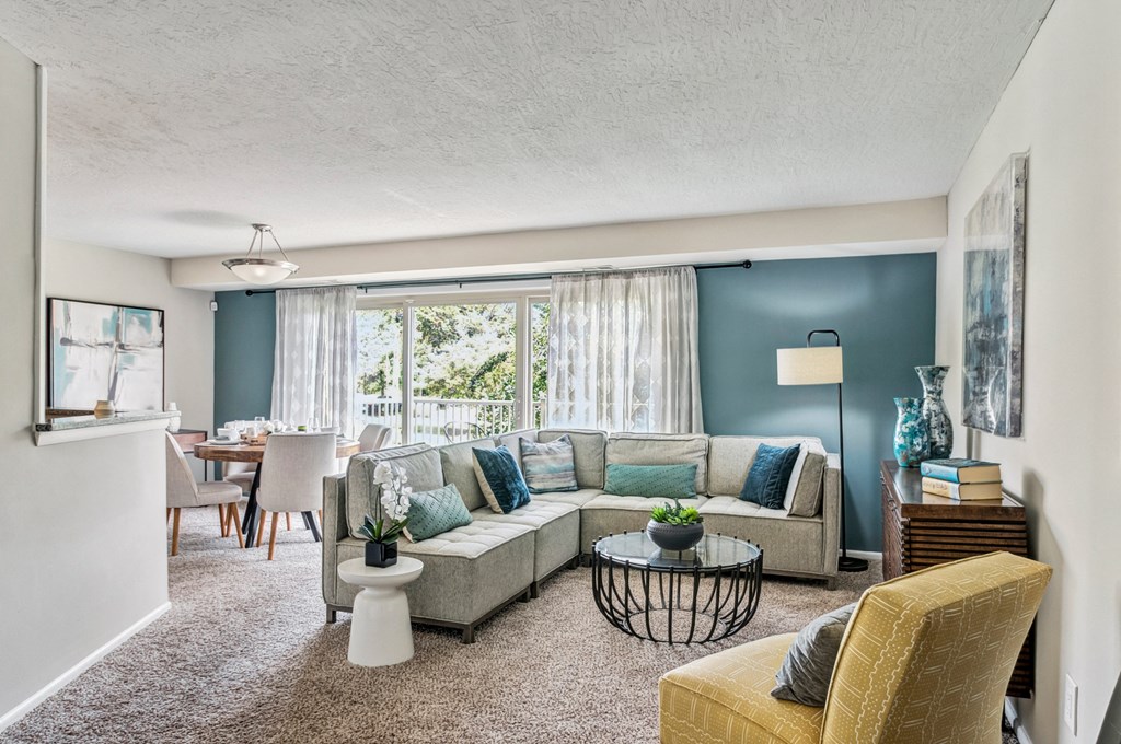 a living room with a couch and a table in front of a window