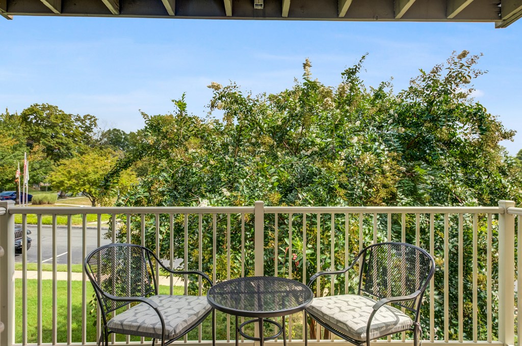 a patio with two chairs and a table on a balcony