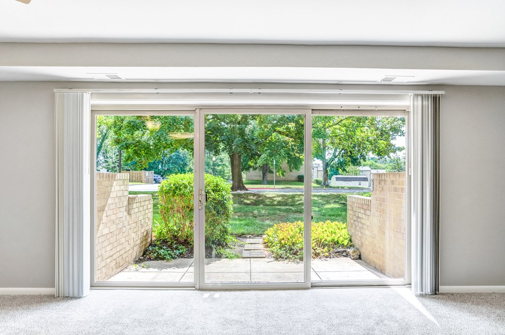 a sliding glass door with a view of a garden