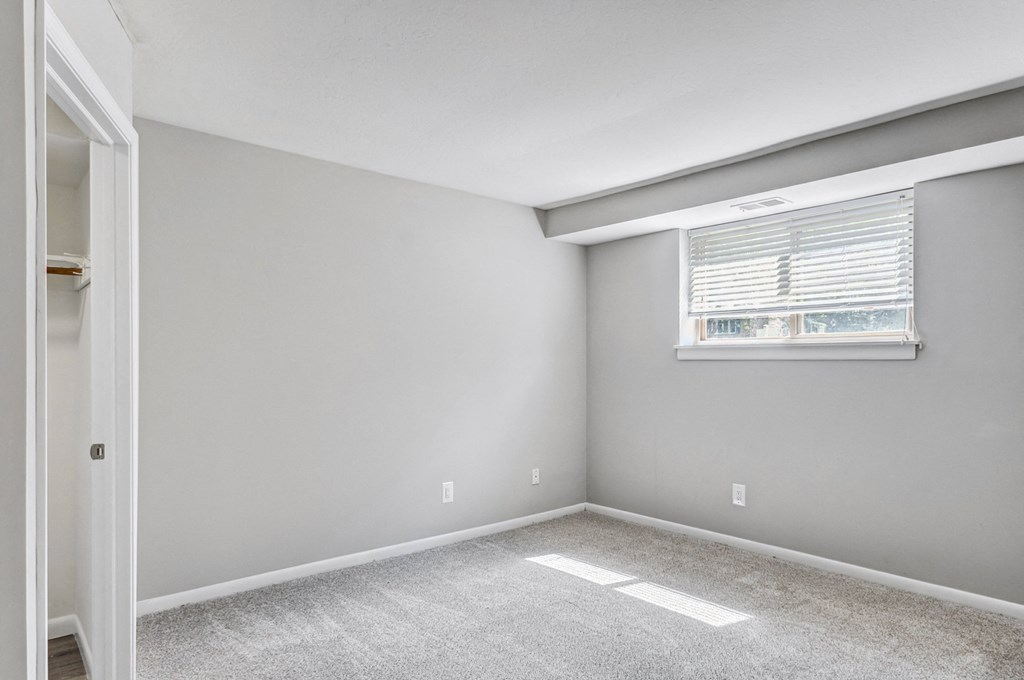 an empty room with white walls and a window