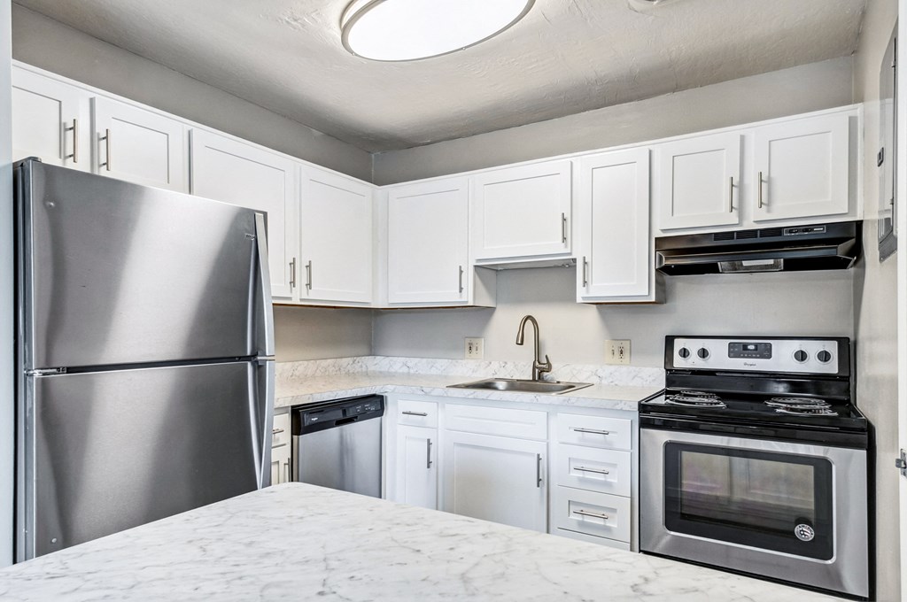 a kitchen with white cabinets and stainless steel appliances