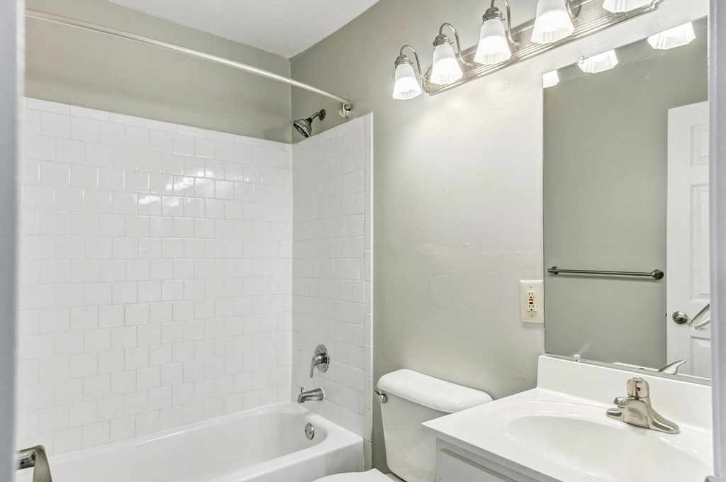 a bathroom with a sink and a tub and a mirror