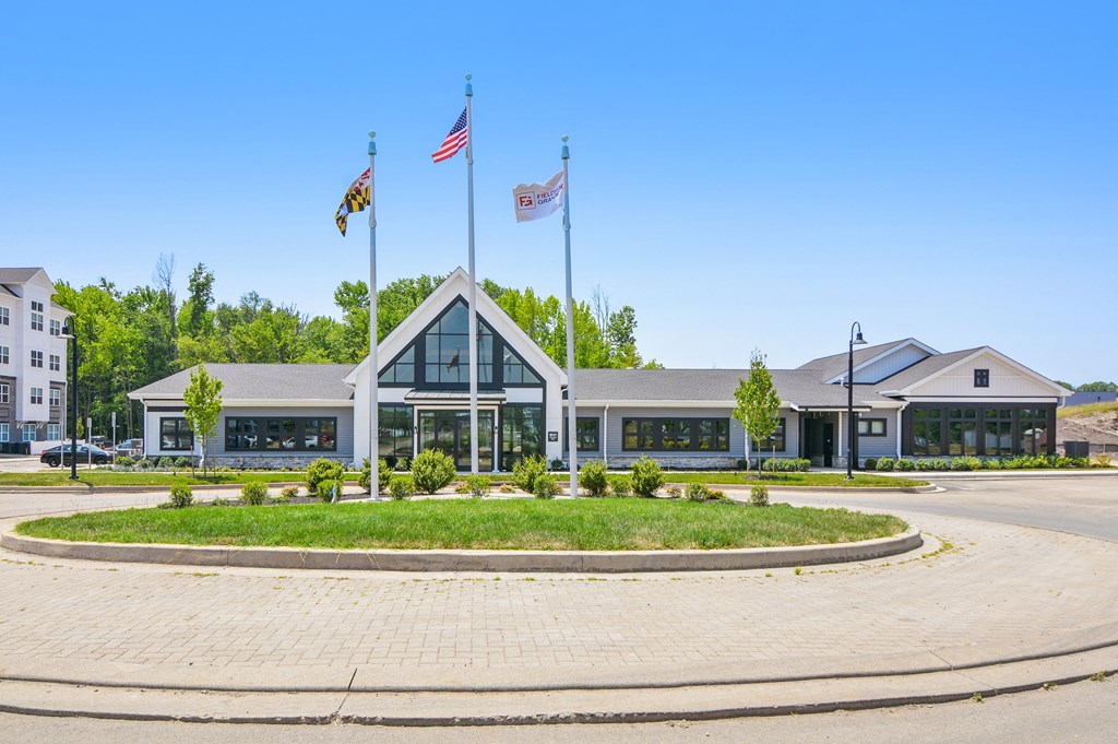 a picture of the front of the building with three flags on the pole in front of it