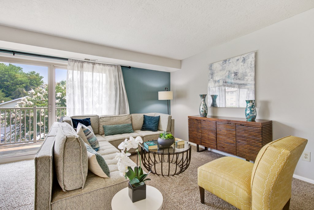 a living room with a couch and a chair and a window