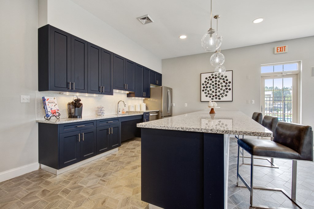 a kitchen with blue cabinets and a marble counter top