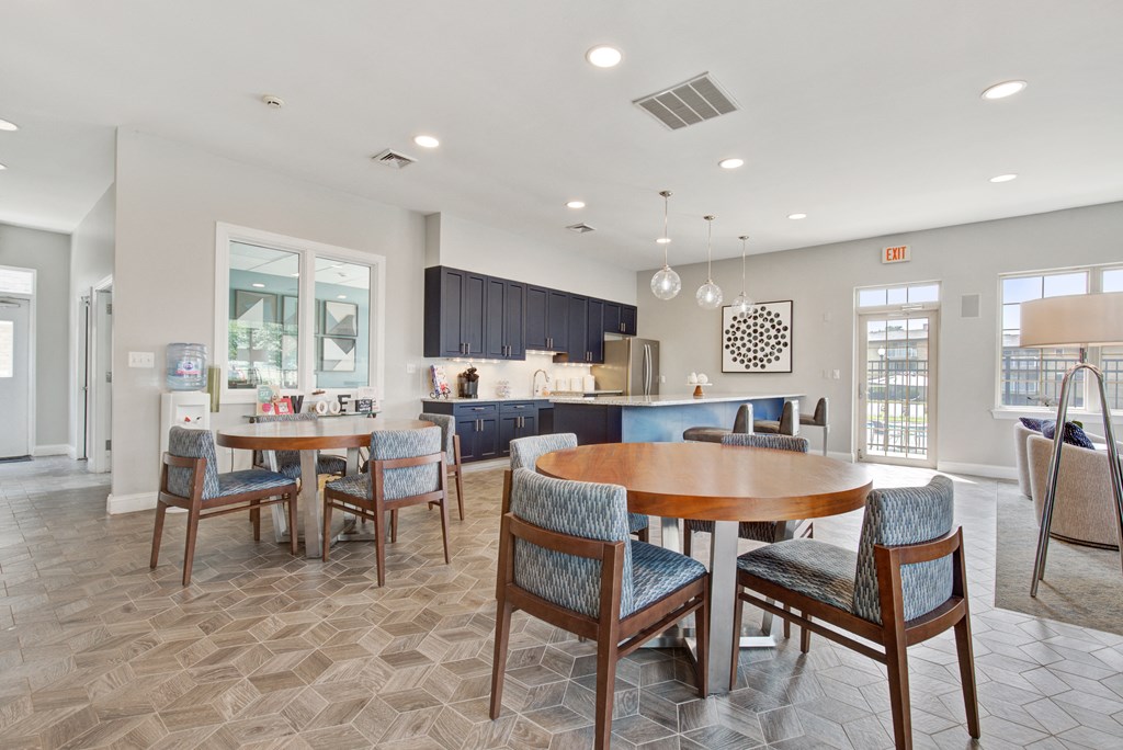 a clubhouse with a dining area and a kitchen with a table and chairs