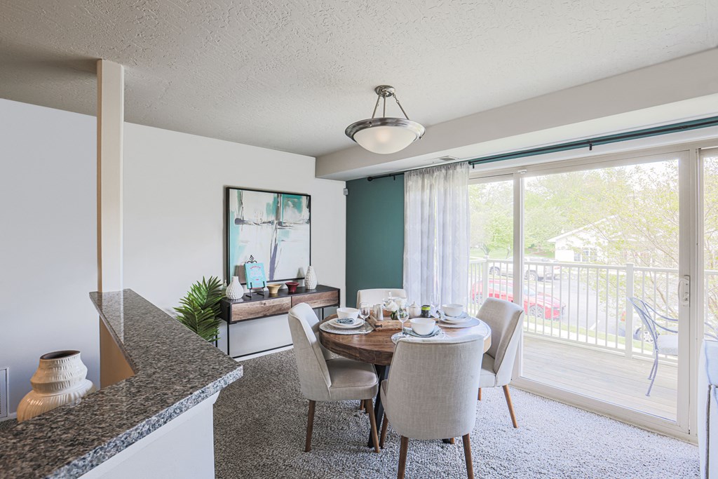a dining area with a table and chairs and a large window