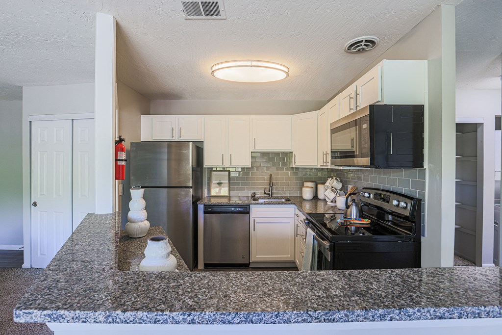 a kitchen with granite countertops and stainless steel appliances
