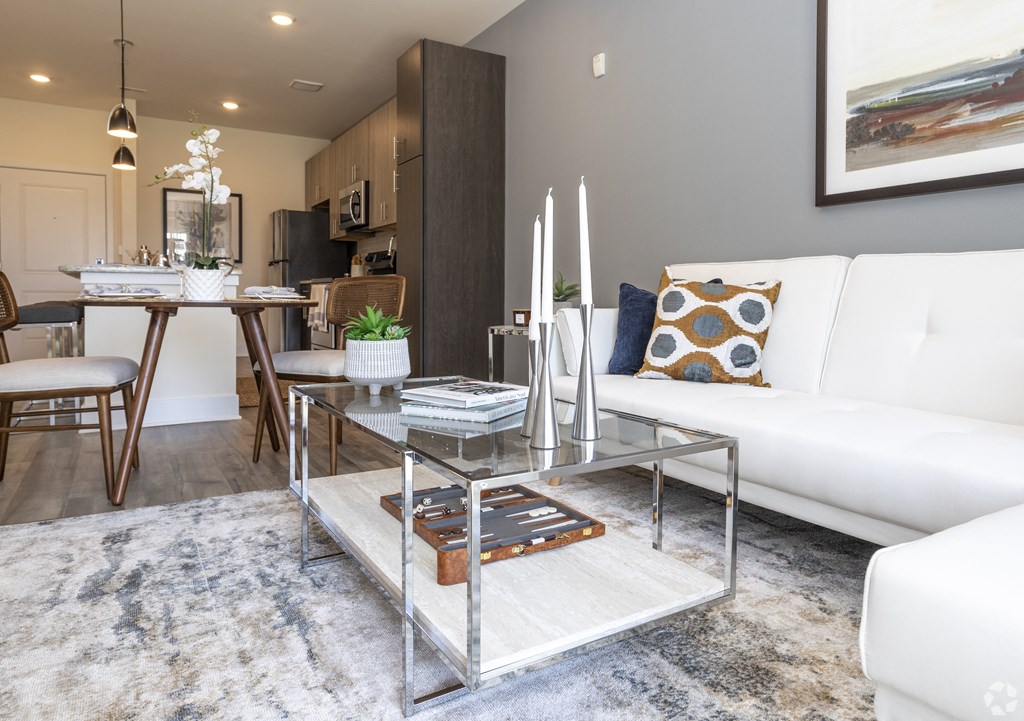 a living room with a white couch and a glass coffee table