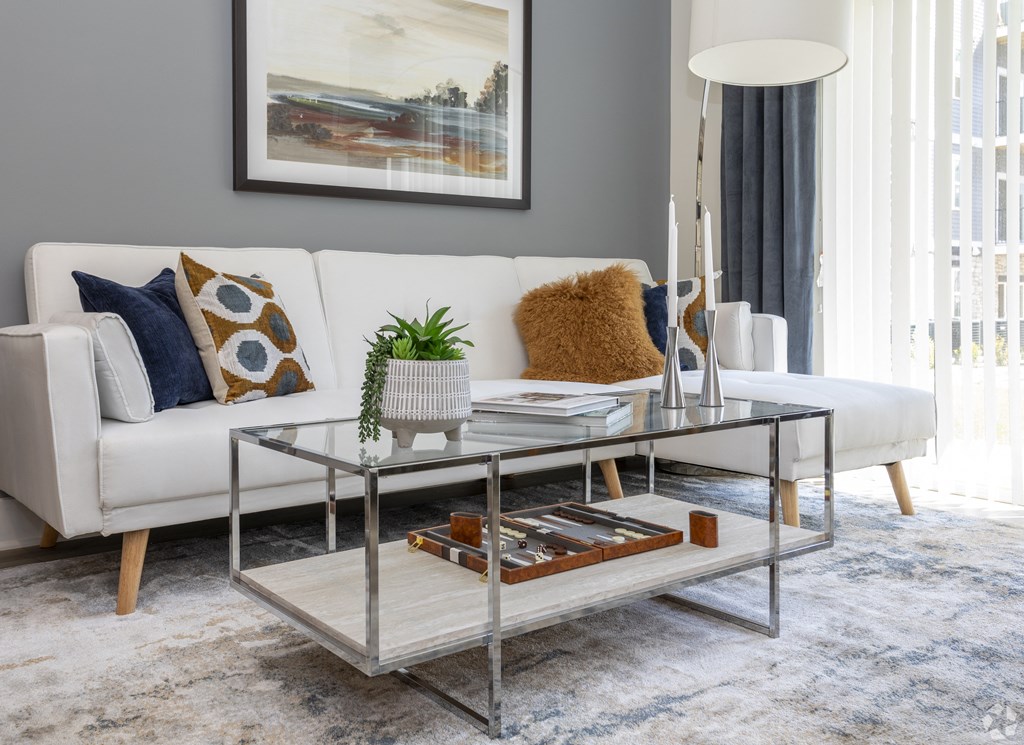 a living room with a white couch and a glass coffee table