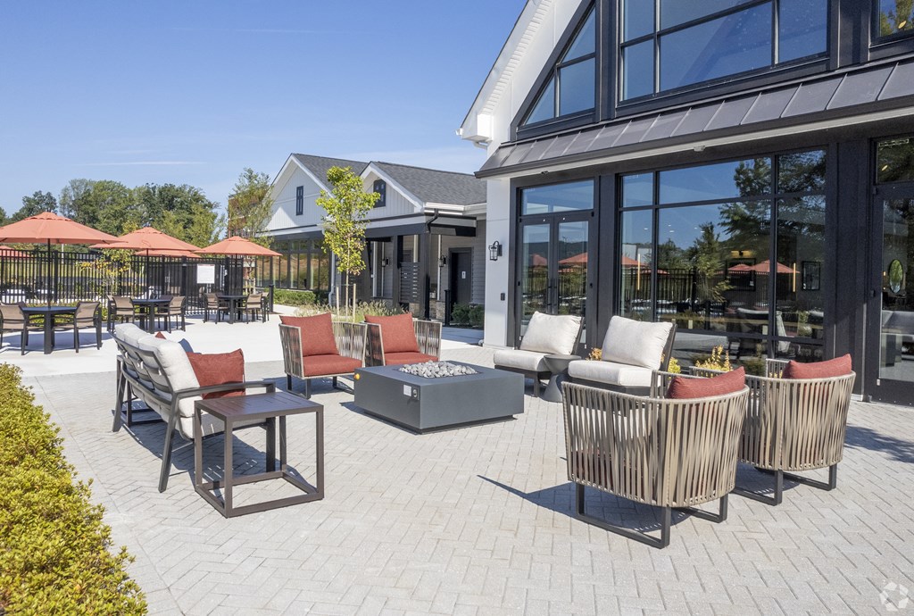 a patio with chairs and tables outside of a building