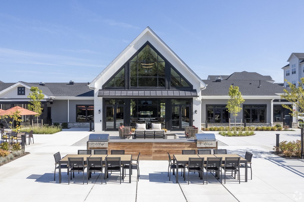 a patio with tables and chairs in front of a building