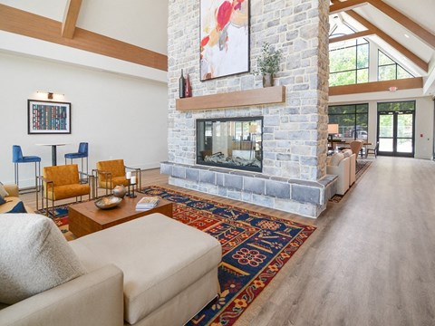 a living room with a stone fireplace and a rug