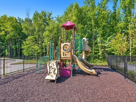 a playground with a swing set and slides in a park