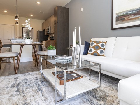 a living room with a white couch and a glass coffee table