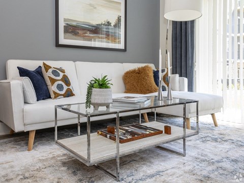 a living room with a white couch and a glass coffee table