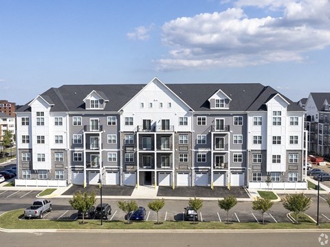 an image of an apartment building in a parking lot
