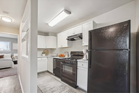 a kitchen with black appliances and white cabinets