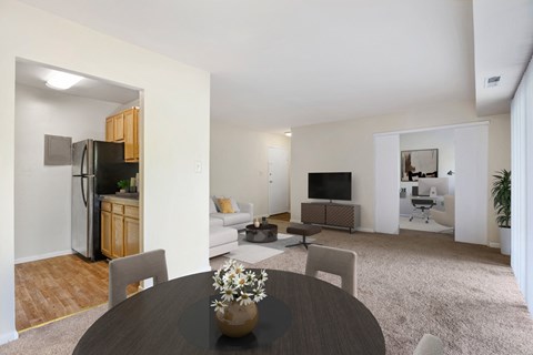 A modern living room with a dining table and chairs.