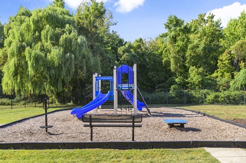 A playground with a blue slide and a blue and white structure.