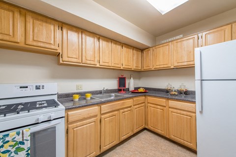 A kitchen with wooden cabinets and a white refrigerator.