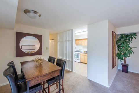 A dining room with a wooden table and chairs.