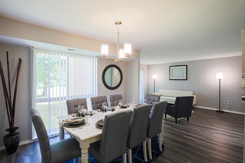 A dining room with a white table and chairs.