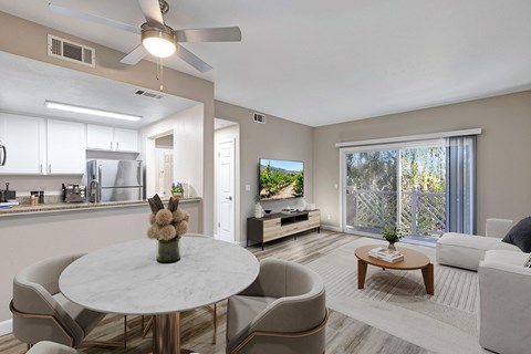 A modern living room with a dining table and chairs.