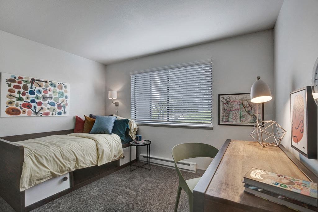 a bedroom with a bed and a desk with a chair