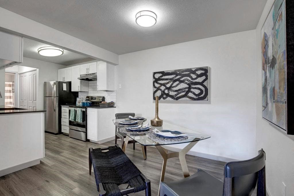 a kitchen and a dining room with a table and chairs
